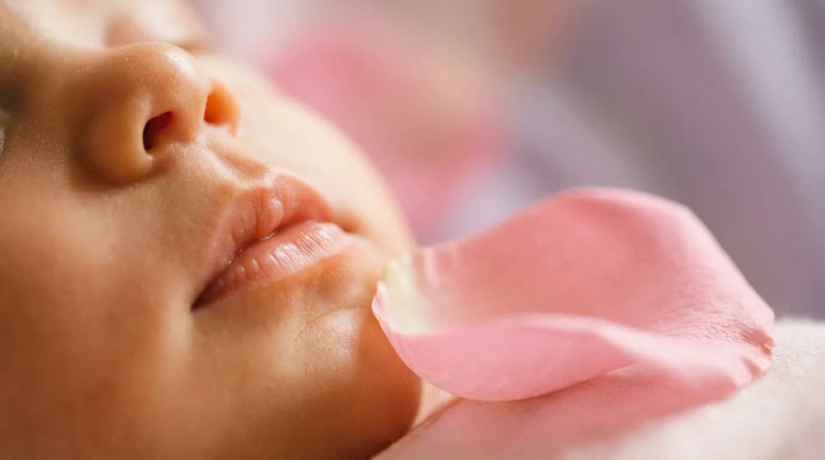 Artistic close-up of newborn baby with close up lips pink rose