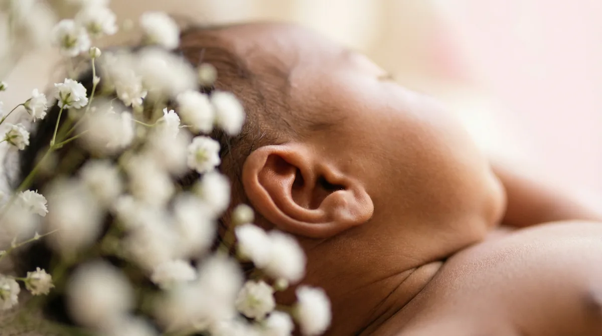 Artistic close-up of newborn baby with close up ear breath